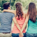 two women and a man hugging