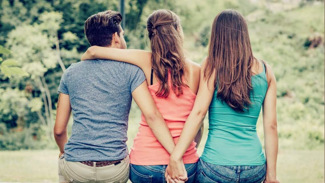 two women and a man hugging