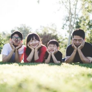 youth-families-square asian family laying in the grass making funny faces