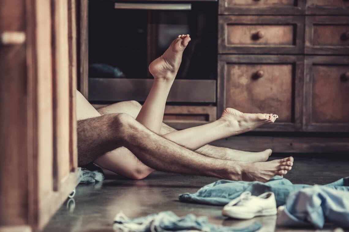 intertwined legs of a man and woman laying on the ground